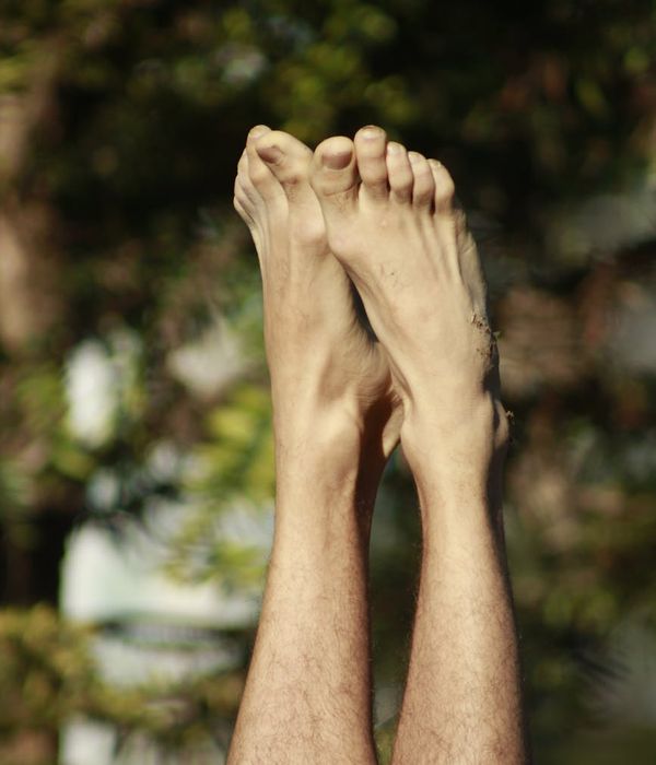 Person balancing in a tree yoga pose against a serene natural background.